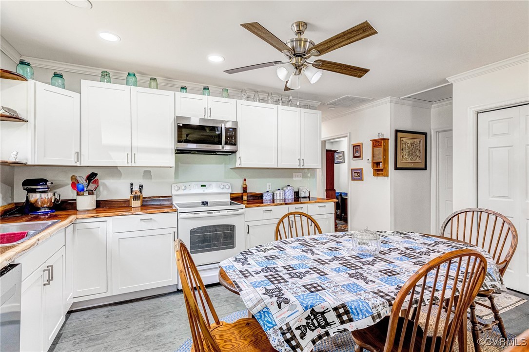 274 Regina Road Lancaster, VA 22503 - Photo 13 of 26 a kitchen with a stove a sink a dining table and chairs