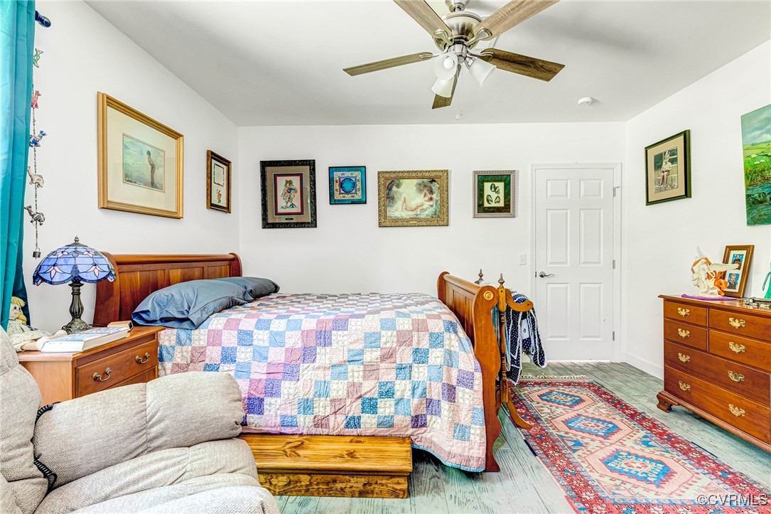 274 Regina Road Lancaster, VA 22503 - Photo 15 of 26 a bedroom with a bed and wooden floor