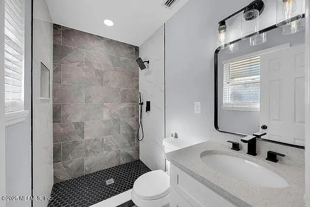 a bathroom with a sink toilet a mirror and shower