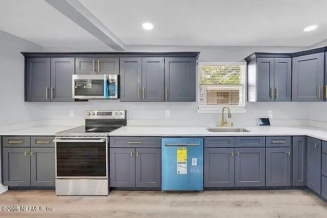 a kitchen with stainless steel appliances granite countertop a stove a sink and a microwave