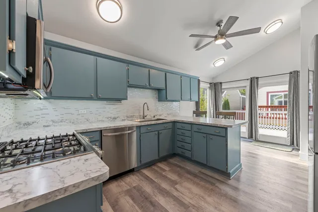 a kitchen with stainless steel appliances granite countertop a sink stove and cabinets