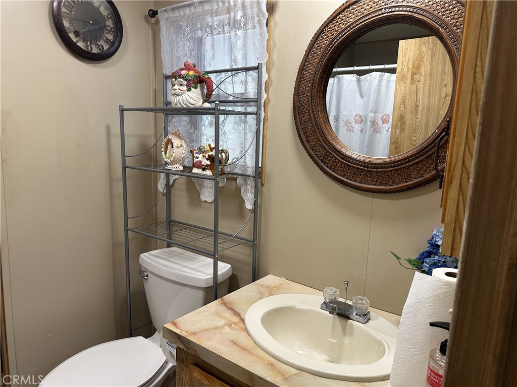 27701 Murrieta Road, Unit 268 Menifee, CA 92586 - Photo 14 of 24 a bathroom with a toilet a sink and a mirror
