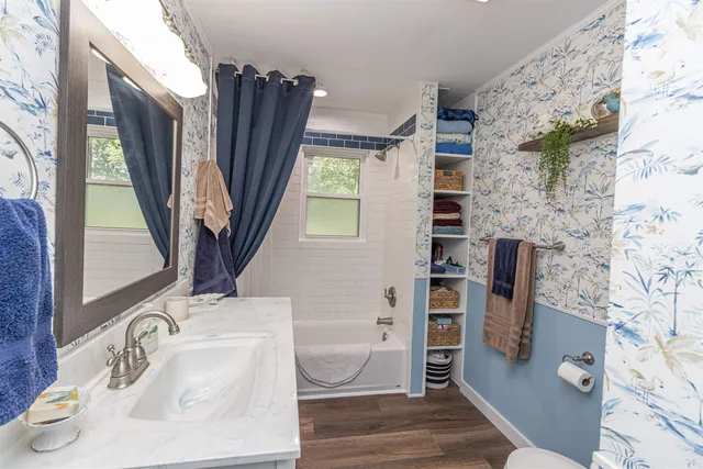 a bathroom with a sink a toilet and a window