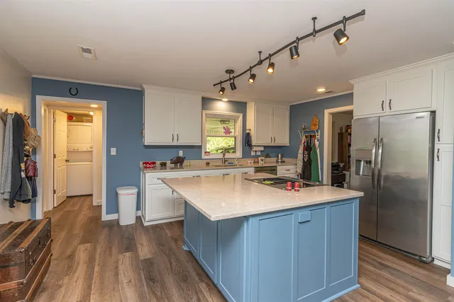 a kitchen with kitchen island a sink stove and refrigerator