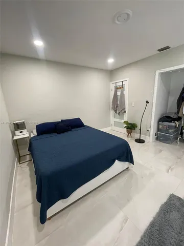 a bedroom with a bed and a view of living room