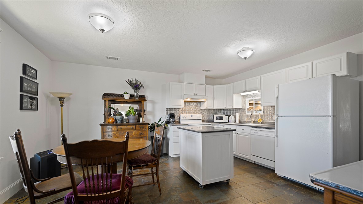 11258 Providence Road Hearne, TX 77859 - Photo 19 of 39 a kitchen with stainless steel appliances a refrigerator a stove a dining table and chairs