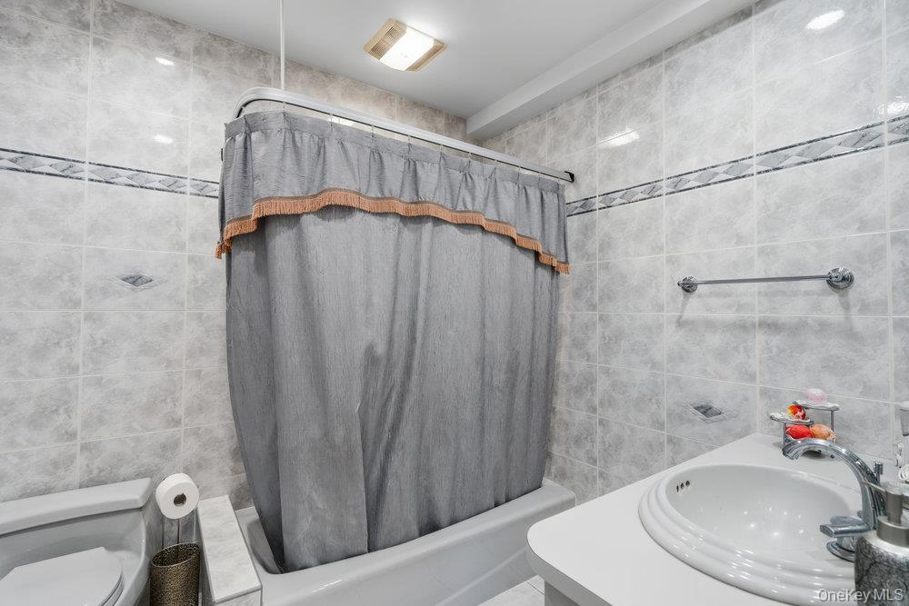 72 Lake End Road Merrick, NY 11566 - Photo 24 of 42 Full bath with vanity, tile walls, and shower / tub combo