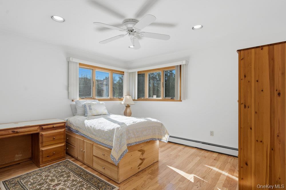 72 Lake End Road Merrick, NY 11566 - Photo 28 of 42 Bedroom featuring a baseboard radiator, ceiling fan, and light wood finished floors