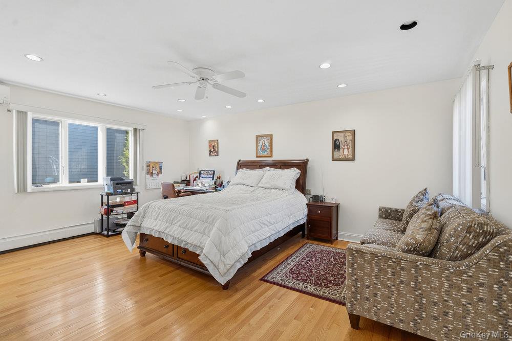 72 Lake End Road Merrick, NY 11566 - Photo 30 of 42 Bedroom with light wood-type flooring, ceiling fan, recessed lighting, and a baseboard radiator