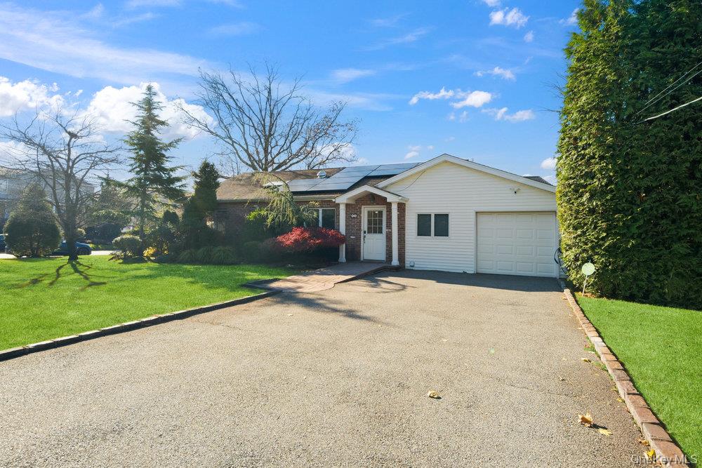 72 Lake End Road Merrick, NY 11566 - Photo 42 of 42 Ranch-style house with a front lawn, roof mounted solar panels, driveway, brick siding, and an attached garage