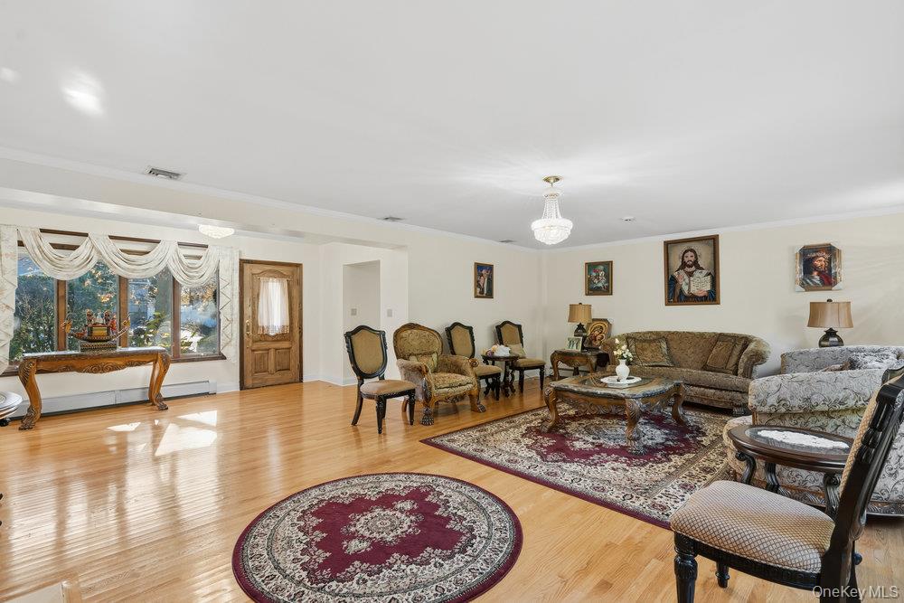 72 Lake End Road Merrick, NY 11566 - Photo 9 of 42 Living room with light wood-style floors, crown molding, and baseboard heating