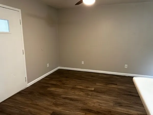 a view of an empty room with wooden floor