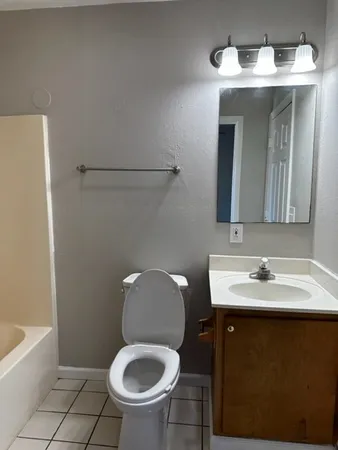 a bathroom with a toilet sink and mirror