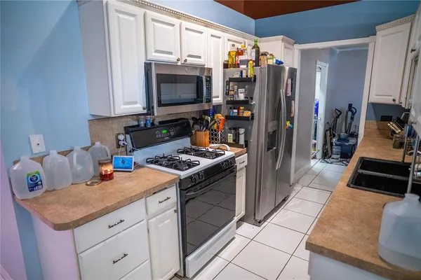 a kitchen with stainless steel appliances a stove refrigerator and microwave