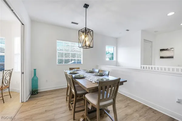 a dining room with furniture a chandelier and wooden floor