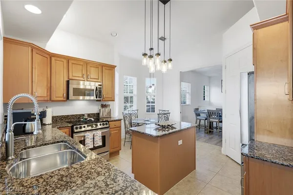 a kitchen with stainless steel appliances granite countertop a sink stove and refrigerator