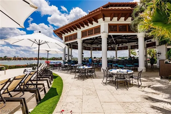 a view of a patio with chairs and tables with umbrella and chairs