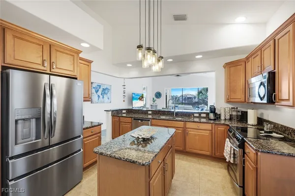 a kitchen with stainless steel appliances granite countertop a refrigerator a stove a sink and a refrigerator
