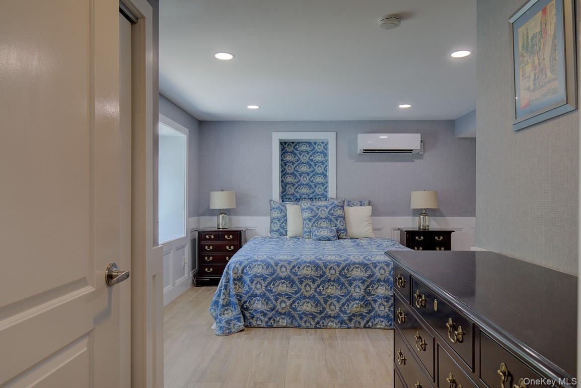 2 Spring Hollow Road Centerport, NY 11721 - Photo 38 of 49 Bedroom with a wall unit AC, light wood-style flooring, and recessed lighting