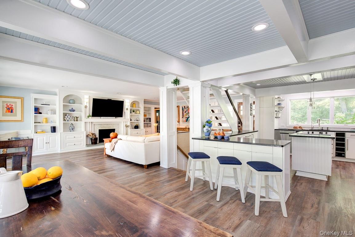 2 Spring Hollow Road Centerport, NY 11721 - Photo 10 of 49 Kitchen featuring ornate columns, dark countertops, a peninsula, beverage cooler, and dark wood-type flooring
