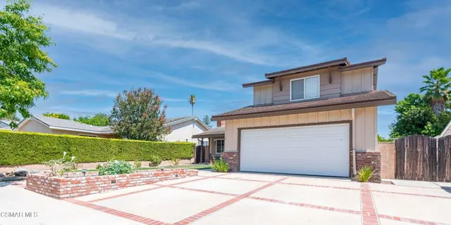 a front view of a house with a garden and plants