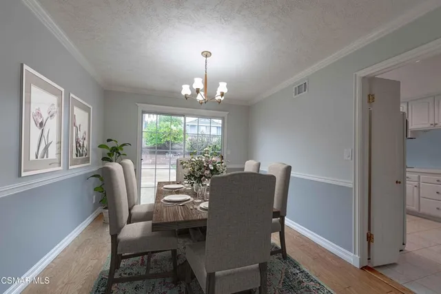 a dining room with furniture a chandelier and window