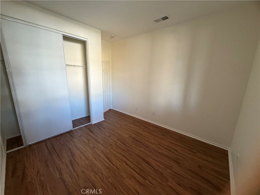 8783 Hunt Canyon Road Corona, CA 92883 - Photo 14 of 24 an empty room with wooden floor and windows