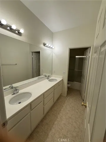 a bathroom with a double vanity sink mirror and shower