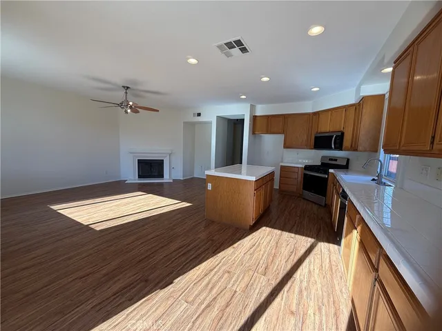 a workspace with stainless steel appliances granite countertop a sink dishwasher and wooden cabinets with a lots of space of countertop