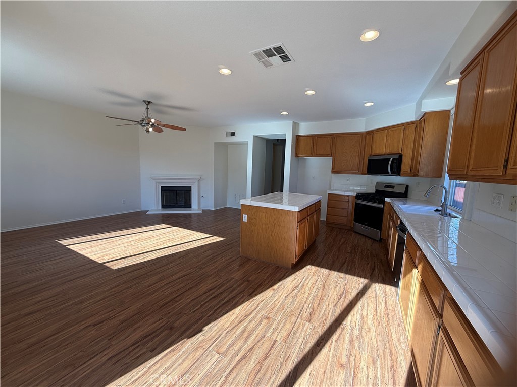 8783 Hunt Canyon Road Corona, CA 92883 - Photo 2 of 24 a workspace with stainless steel appliances granite countertop a sink dishwasher and wooden cabinets with a lots of space of countertop