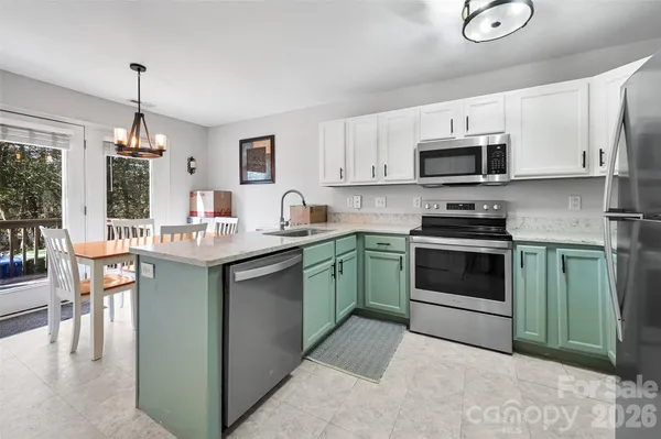 a kitchen with stainless steel appliances granite countertop a sink dishwasher a stove and a microwave oven with cabinets