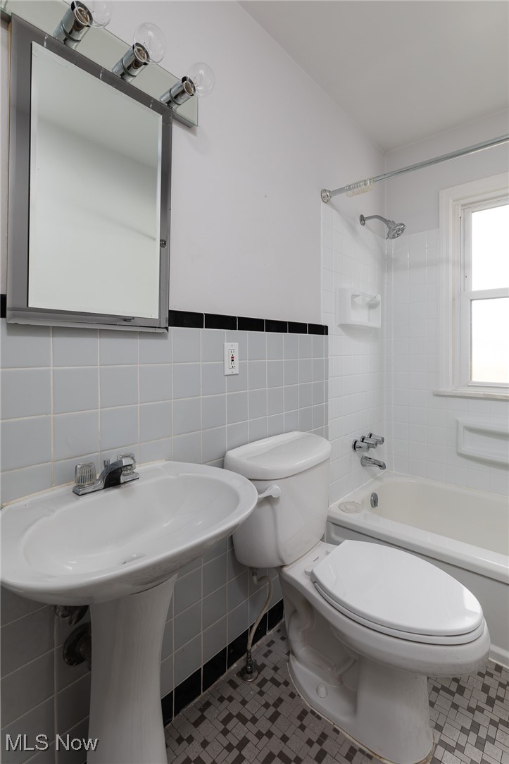 32003 Dickerson Road Willowick, OH 44095 - Photo 16 of 25 Bathroom featuring tiled shower / bath combo, tile walls, toilet, and tile patterned floors