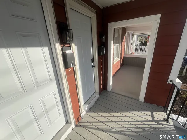 a view of a hallway with wooden floor and stairs