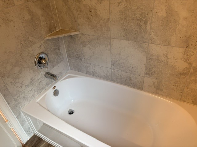6917 Colorado Bluffs Road Austin, TX 78744 - Photo 13 of 19 a bathroom with a white bath tub and a shower