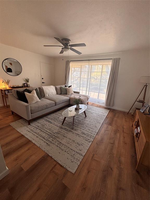 8057 Meadow Road, Unit 202 Dallas, TX 75231 - Photo 3 of 11 Living area featuring a ceiling fan, dark wood-style flooring, and a textured ceiling