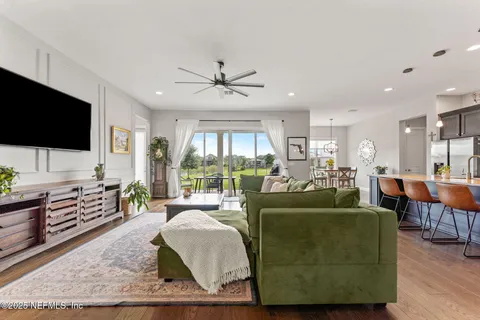 a living room with furniture a flat screen tv and a large window