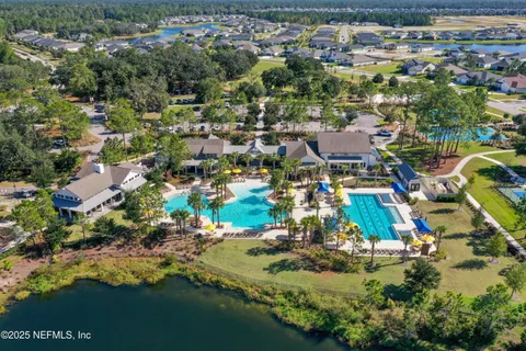 an aerial view of residential houses with outdoor space and trees