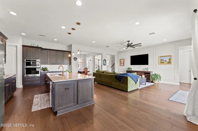 a large living room with stainless steel appliances granite countertop a couch and a flat screen tv
