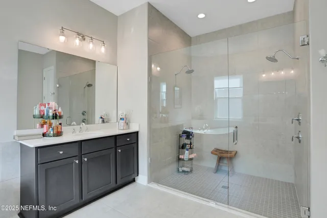 a bathroom with a sink mirror and a shower