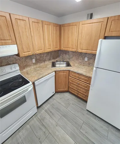 a kitchen with granite countertop white cabinets and white appliances