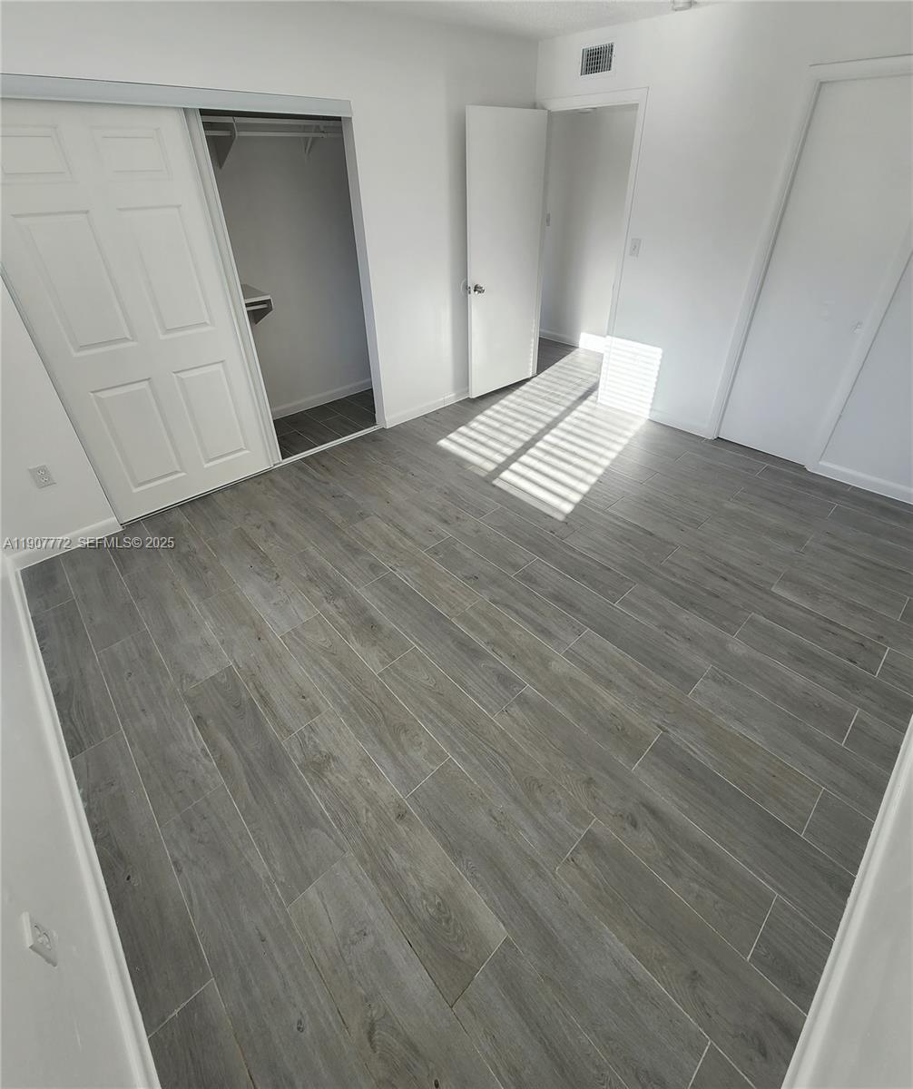 10900 Southwest 196th Street, Unit 213 Cutler Bay, FL 33157 - Photo 11 of 15 an empty room with wooden floor