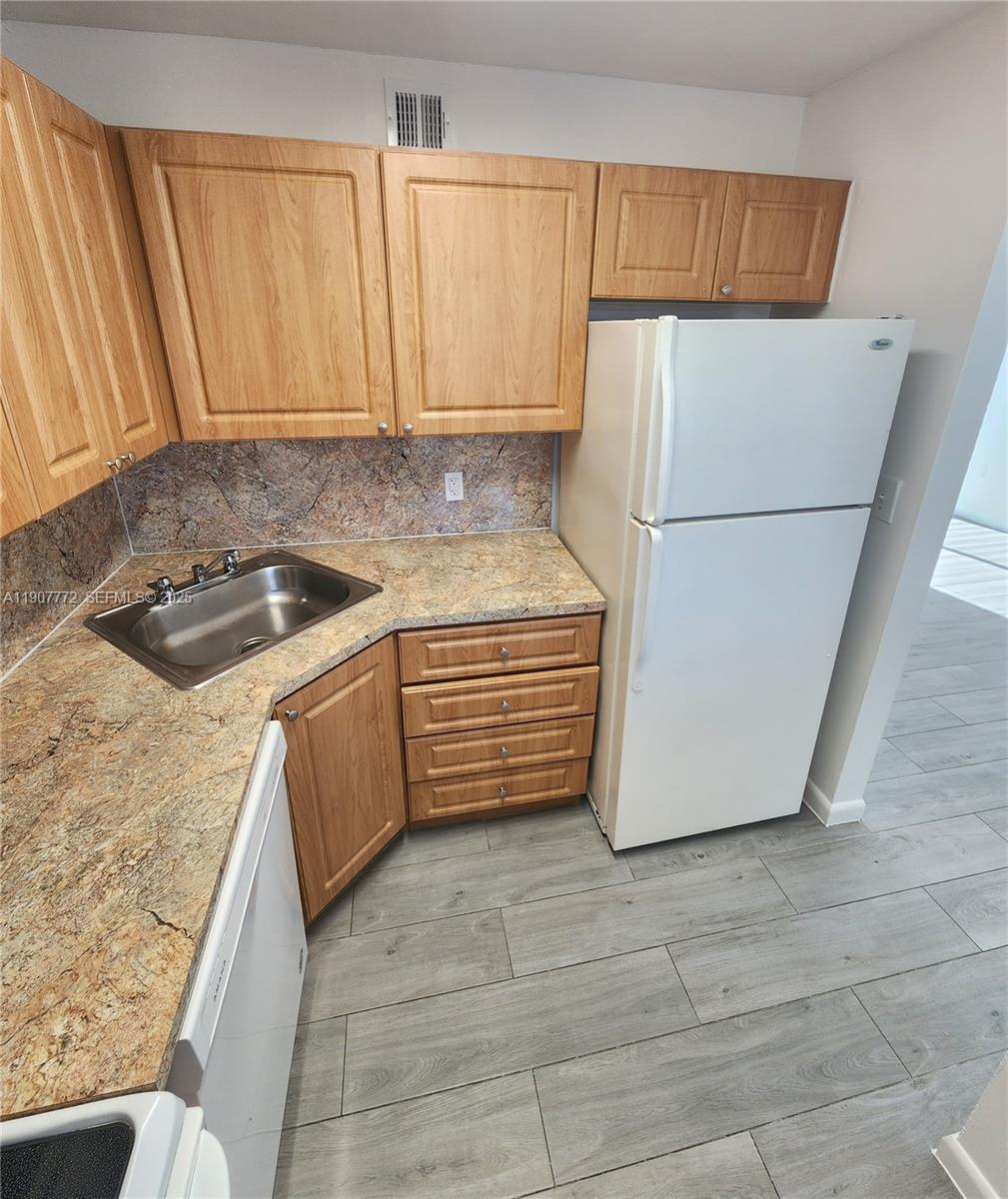 10900 Southwest 196th Street, Unit 213 Cutler Bay, FL 33157 - Photo 3 of 15 a kitchen with a sink a stove and a refrigerator