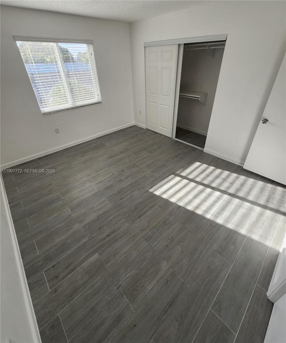 10900 Southwest 196th Street, Unit 213 Cutler Bay, FL 33157 - Photo 10 of 15 a view of an empty room and wooden floor