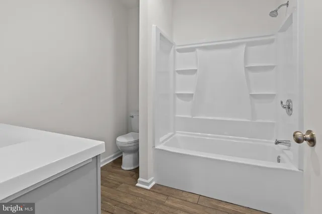 a bathroom with a granite countertop toilet a sink and bathtub