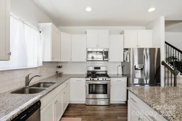 a kitchen with stainless steel appliances granite countertop a sink stove and refrigerator