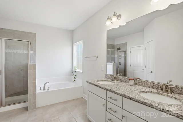 a spacious bathroom with a granite countertop tub sink and mirror