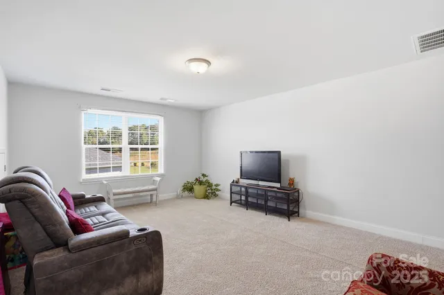 a living room with furniture a ceiling fan and a window