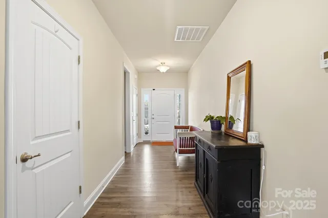a view of a hallway with a table and chairs