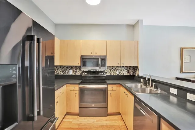 a kitchen with stainless steel appliances granite countertop a sink stove and refrigerator
