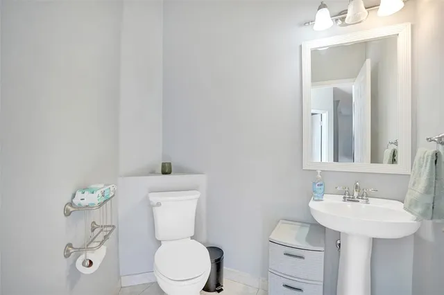 a bathroom with a toilet a sink and mirror